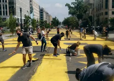  ??  ?? Le 5 juin, à Washington, l’avenue qui mène à la Maison-Blanche a été rebaptisée Black Lives Matter Plaza et le nom du mouvement (« Les vies noires comptent »), peint en lettres géantes sur la chaussée.