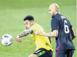  ?? AP ?? Jamaica’s Andre Gray shielding the ball from John Brooks of the United States during an internatio­nal friendly match in March.