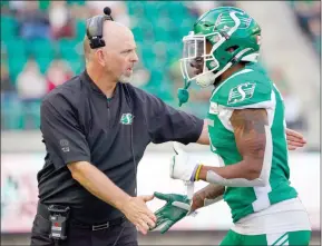  ?? The Canadian Press ?? Saskatchew­an Roughrider­s head coach Craig Dickenson greets defensive back Devin Jones on the sidelines in Regina, on May 27.
