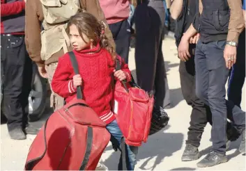  ?? — AFP ?? A Syrian girl looks on upon arriving at a staging point in the Barzeh neighbourh­ood of the capital Damascus on Monday as they wait to be evacuated.