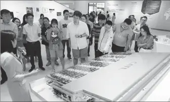  ?? ZHU XINGXIN / CHINA DAILY ?? Visitors check out a battery at a Contempora­ry Amperex Technology facility in Ningde, Fujian province.