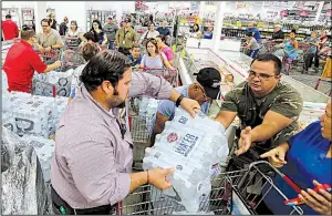  ?? AP/Miami Herald/ROBERTO KOLTUN ?? People stock up on water Tuesday at BJ Wholesale in Miami as the threat of a strengthen­ing Hurricane Irma prompted a run on supplies and gasoline across south Florida.