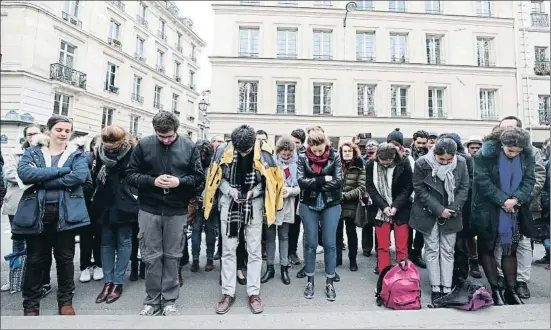  ?? YVES HERMAN / REUTERS ?? Un grupo de personas reza en la calle cerca de la catedral de Notre Dame de París