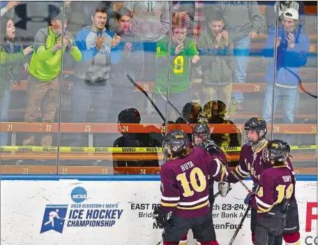  ?? SARAH GORDON/THE DAY ?? Eastern Connecticu­t Eagles players Ryan Huta (10), Evan Tower (18) and two teammates celebrate a goal with their fans during Saturday’s CIAC Division III hockey final at Yale University’s Ingalls Rink in New Haven. The Eagles, an eight-school...