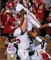  ?? ASSOCIATED PRESS ?? ALABAMA OFFENSIVE LINEMAN Bradley Bozeman (75) hoists wide receiver DeVonta Smith (6) as they celebrate Smith’s 26yard touchdown pass reception for the go-ahead score during the fourth quarter of Saturday’s game in Starkville, Miss.