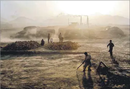  ??  ?? Dust and dedication: Harsh conditions (above) don’t deter cricket enthusiast­s as they play on the outskirts of Kabul.
Fans (left) line up ahead of the Shpageeza Cricket League T20 tournament at the Alokozay Kabul Internatio­nal Cricket Ground.