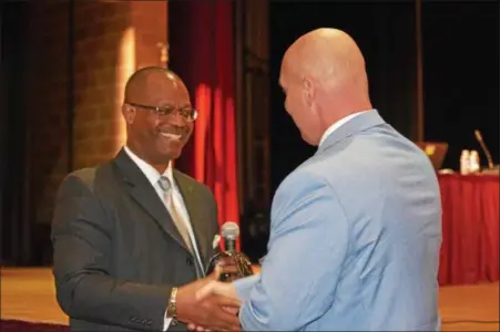  ?? MARIAN DENNIS — DIGITAL FIRST MEDIA ?? Dana T. Bedden, left, who was approved Tuesday, July 24, as the new superinten­dent of the Boyertown Area School District, receives a gift as he is welcomed to the district as a “Boyertown Bear.”