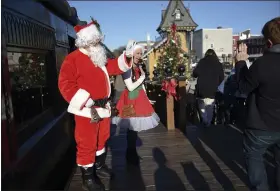  ?? LAUREN A. LITTLE — MEDIANEWS GROUP ?? Santa (aka Steven Dapcevich) and his helper Natalie Bonacci wave to children after a ride on the Colebrookd­ale Railroad’s Santa’s Polar Bear Express.