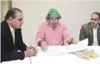  ?? ADRIANO ROSARIO/LISTÍN DIARIO ?? VISITA. El padre Rogelio Cruz (centro) junto a su abogado presenta al director del Listín Diario, Miguel Franjul, documentac­ión para avalar su argumento de que no tiene un hijo biológico.