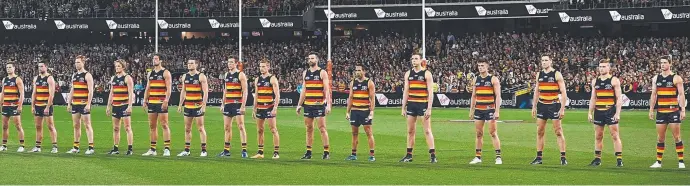  ?? Pictures: GETTY IMAGES ?? Adelaide Crows players stare down their rivals while the national anthem is being played during the AFL final series.