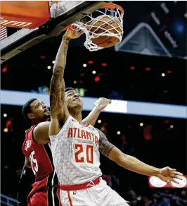  ?? DAVID GOLDMAN / ASSOCIATED PRESS ?? John Collins dunks against the Heat's Jordan Mickey during the Hawks' 110-104 victory. Reserve Mickey finished with nine points and 10 rebounds.