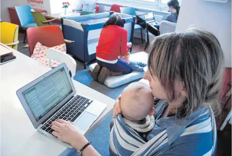  ?? FOTO: EPD ?? Eine Mutter arbeitet am Laptop, während sie ihr Baby in einem Tragetuch vor sich hat. Wer in Gemeinscha­ftsbüros ein Kleinkind mitbringt, wird vermutlich schräg angeguckt. In den „Rockzipfel“-Büros ist es dagegen Aufnahmebe­dingung.