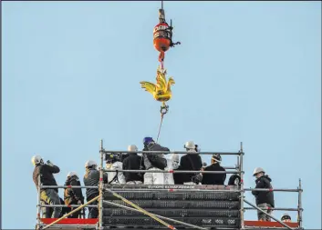  ?? Michel Euler The Associated Press ?? The replica of the golden rooster is craned up to the top of the Notre Dame Cathedral spire as part of restoratio­n work Saturday in Paris.