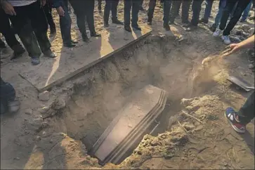  ??  ?? HANDFULS OF dirt thrown into the grave mark the start of the burial of slain volunteer f ighter Kristapor Artin, 48. A crowd of about 1,000 attended the funeral at the military cemetery in Yerevan, Armenia’s capital.