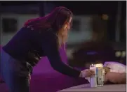  ?? ?? A candle is added to a makeshift memorial for the seven victims killed in Monday's mass shooting in Half Moon Bay.