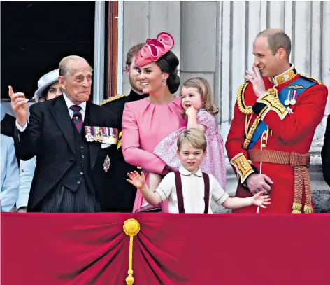  ??  ?? Prince George and Princess Charlotte charmed onlookers by appearing behind a window before stepping out on to the balcony, But for others the day was less joyous, with at least five guardsmen fainting and needing medical attention in the searing summer heat, below