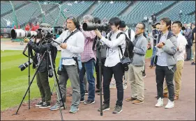  ?? TED S. WARREN / ASSOCIATED PRESS FILE (2019) ?? Members of the Japanese media watch Ohtani, then with the Los Angeles Angels, throw May 19, 2019, during batting practice before a game against the Seattle Mariners in Seattle.