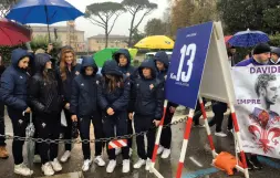  ??  ?? Davanti al cartellone­La Firenze Marathon ha deciso di dedicare il tredicesim­o chilometro del percorso, sui Lungarni, al capitano della Fiorentina Davide Astori, scomparso il 4 marzo scorso, che indossava la maglia numero 13 appunto. A fare festa in sua memoria i piccoli della Fiorentina e, a sorpresa, col vicepresid­ente viola Gino Salica, a sinistra, i genitori del calciatore