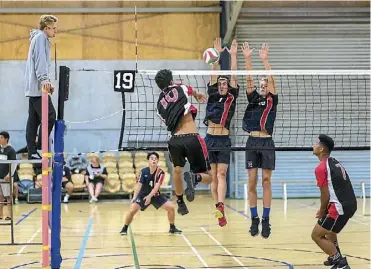  ??  ?? Hamlton Boys’ High School’s Jaenyn Paama (No.10) gets one through the defence of Riccarton High in their opening match of the Secondary Schools Volleyball Nationals in Palmerston North on Monday. In support is Thomas Falekaono.