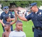  ?? PROVIDED BY CAMDEN COUNTY POLICE DEPARTMENT ?? Camden County Police Chief Gabriel Rodriguez, right, high-fives a member of the community. Rodriguez said violent crime has dropped significan­tly in the city and officers spend more time getting to know citizens.