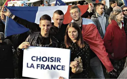  ??  ?? Jovens seguram cartaz escrito ‘Escolher a França’ em comício da candidata Marine Le Pen em Ennemain, norte do país
