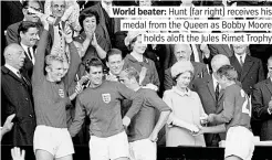  ?? ?? World beater: Hunt (far right) receives his medal from the Queen as Bobby Moore holds aloft the Jules Rimet Trophy