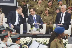  ?? (Marc Israel Sellem/The Jerusalem Post) ?? PRIME MINISTER Naftali Bennett and President Isaac Herzog share a word as Defense Minister Benny Gantz looks on during a ceremony yesterday at the President’s Residence in Jerusalem.