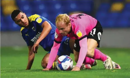  ?? Photograph: Tom Dulat/Getty Images ?? Peterborou­gh, whose midfielder Ryan Broom (right) is in action here against AFC Wimbledon, are among the teams who want the PFA to fund Covid tests.