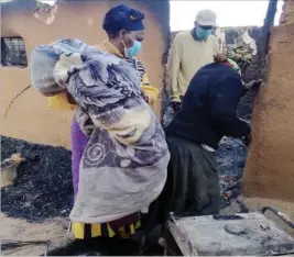  ??  ?? Nkayi South MP Cde Stars Mathe donates blankets to a family whose bedroom hut was gutted by fire