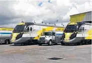  ?? WAYNE K. ROUSTAN/STAFF ?? At top, upgrade work at a railroad crossing on Miami Gardens Drive was being done this week to accommodat­e the highspeed trains. Above, Brightline trains sit in a railyard in West Palm Beach, where they are tested to help train onboard crews. It’s not...