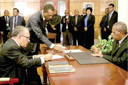  ?? Photo: PNC People’s National Congress ?? The Prime Minister of Papua New Guinea, Peter O’Neill, left, signs his Oath of Office before Governor-General, Bob Dadae at Government House, Port Moresby on August 2, 2017.