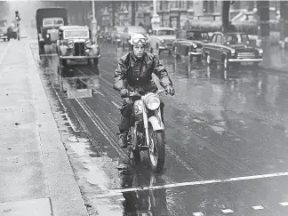  ?? ?? We pulled out lots of city traffic photos from back issues of The Motor Cycle and Motor Cycling to illustrate this feature. On a wet and miserable day, a rider stops at a pedestrian crossing, closely followed by what appear to be an old Daimler saloon and a Commer lorry.