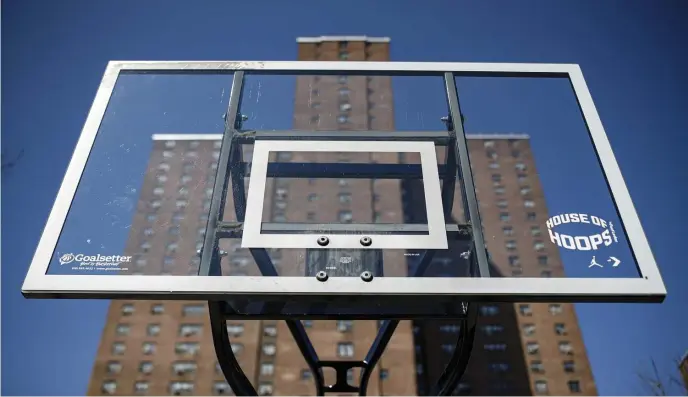  ?? AP FILe PHOTOs ?? NO GAMES: Basketball backboards stand without rims after New York City officials had them removed to reduce gatherings at Rucker Park in Harlem. The COVID-19 pandemic has left the New York street ball scene quiet. At far right, spectators watch one of the basketball games during the World Basketball Festival at Rucker Park in New York in the past.