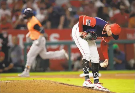  ?? Jae C. Hong Associated Press ?? ANGELS STARTER Andrew Heaney picks up the rosin bag after giving up a fifth-inning grand slam to Houston’s Marwin Gonzalez.