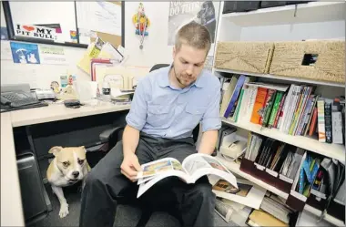  ?? JED KIRSCHBAUM/ BALTIMORE SUN ?? Budge stays close to his owner, Michael Walley-Rund, at MICA in Baltimore, Md. Companies large and small are allowing pets to share office space as a small perk.