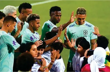  ?? EFE ?? LEVANTAN PASIONES
Los jugadores de Brasil saludan a unos ni
ños sobre el campo de entrenamie­nto después de una sesión de preparació­n en Doha, antes del debut
ante Serbia.