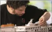  ?? MARY ALTAFFER — THE ASSOCIATED PRESS ?? Ricardo Martinez, of Argentina, puts final touches on a cruise ship in the Latin America section of the Gulliver’s Gate exhibit, Wednesday in New York.