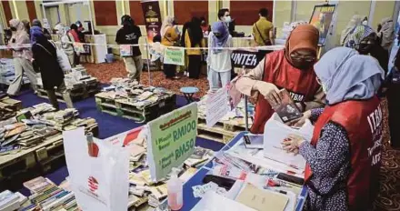  ?? (Foto Asyraf Hamzah/bh) ?? Pengunjung tidak melepaskan peluang membeli buku dengan potongan harga pada hari terakhir PBAKL 2022 di Pusat Dagangan Dunia, semalam.