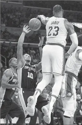  ?? Photograph­s by Allen J. Schaben Los Angeles Times ?? LeBRON JAMES, who had 32 points, eight rebounds and 14 assists, blocks a shot by San Antonio Spurs guard DeMar DeRozan in the first half.