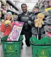  ?? Contribute­d ?? Felicity and Bryson, with their RCMP partner Const. Lorde, take a moment to show some of the gifts that they have selected for their family members this Christmas.