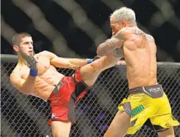  ?? GIUSEPPE CACACE AFP VIA GETTY IMAGES ?? Islam Makhachev (left) battles Charles Oliveira for UFC lightweigh­t crown.