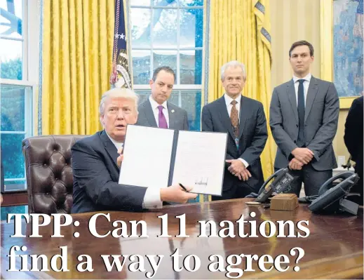  ?? Picture / Bloomberg ?? President Donald Trump with the executive order withdrawin­g the US from the planned TransPacif­ic Partnershi­p.