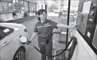  ?? -AP ?? An employee of a gas station fuels a car in Xinle city, Hebei province in China.