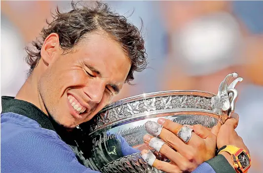  ?? — AP ?? Rafael Nadal holds the trophy as he celebrates winning the French Open title at the Roland Garros stadium in Paris, France, on Sunday.