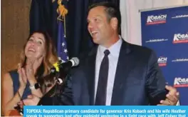  ??  ?? TOPEKA: Republican primary candidate for governor Kris Kobach and his wife Heather speak to supporters just after midnight yesterday in a tight race with Jeff Colyer that is too close to call. — AFP