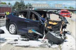  ??  ?? The Associated Press Emergency personnel work at the scene March 28 where a Tesla electric SUV crashed into a barrier on U.S. Highway 101 in Mountain View, Calif., killing its driver.