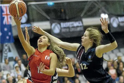  ?? WARWICK SMITH/STUFF ?? Manukura captain Brody Manson, left, goes for the layup against Megan Ellis of Ellesmere College in the A final of the national secondary schools basketball championsh­ips.