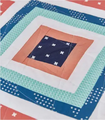  ??  ?? A pop of navy blue in the centre of these log-cabin look blocks really makes this quilt sing!