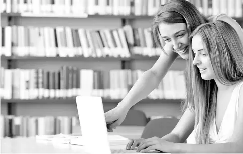  ??  ?? Two students accessing informatio­n on the internet at a library.