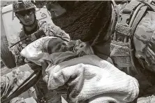  ?? Getty Images ?? Afghan troops carry a newborn from a Kabul hospital that gunmen held siege, killing two newborns and 14 others, on Tuesday.